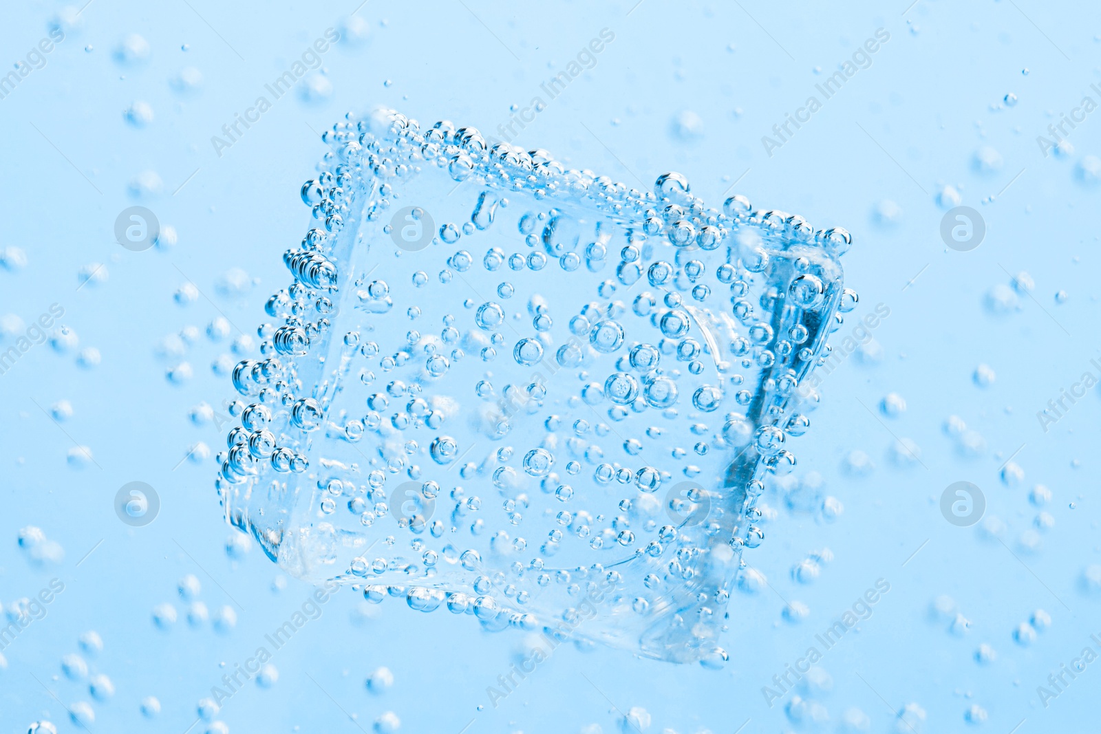 Soda water with bubbles and ice cube as background, closeup Image of Soda water with bubbles and ice cube as background, closeup