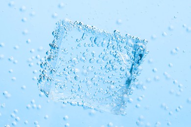 Image of Soda water with bubbles and ice cube as background, closeup