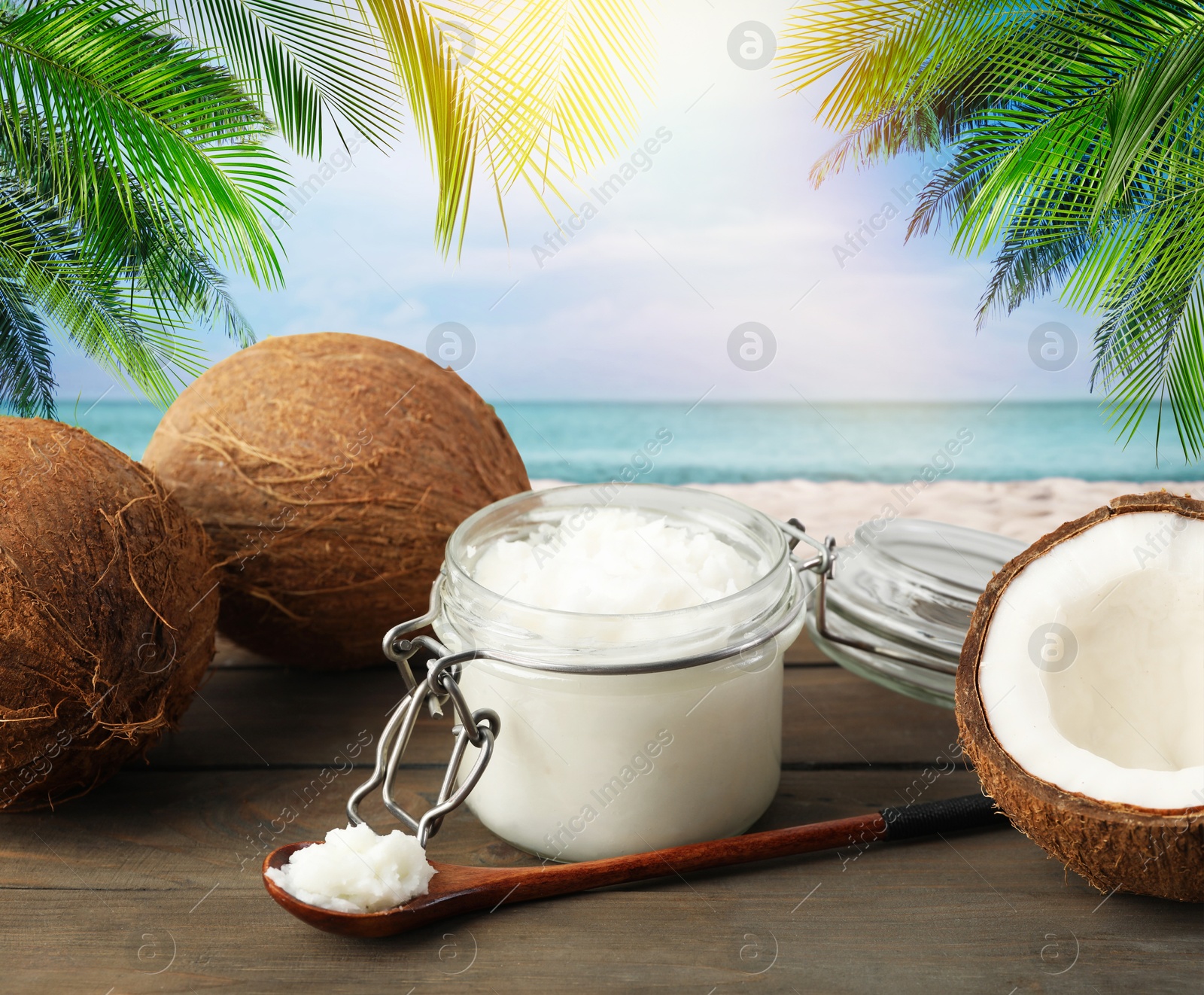 Cooking oil in jar and coconuts on wooden table against beach Image of Cooking oil in jar and coconuts on wooden table against beach