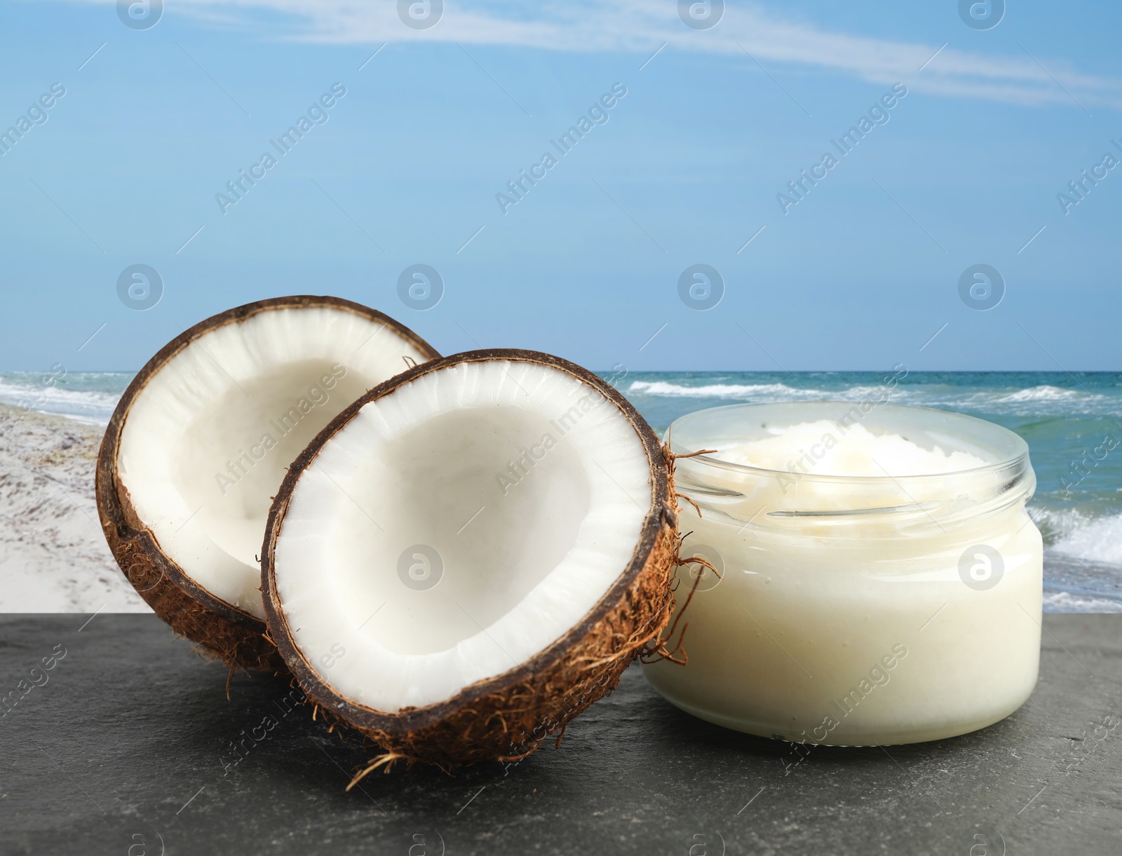 Cooking oil in jar and coconut on table against beach Image of Cooking oil in jar and coconut on table against beach