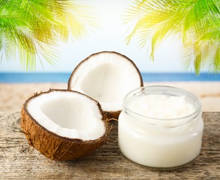 Image of Cooking oil in jar and coconut on wooden table against beach