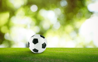 Image of Soccer ball on green grass outdoors, space for text. Football game