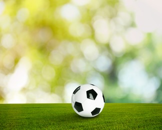 Soccer ball on green grass outdoors. Football game