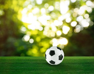 Image of Soccer ball on green grass outdoors. Football game