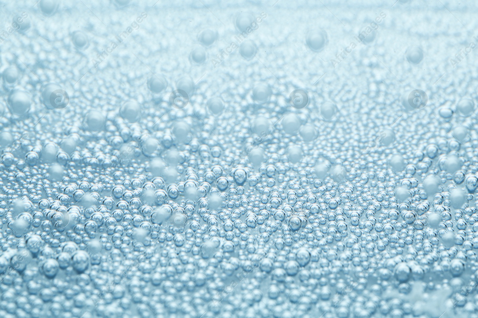 Soda water with bubbles as background, closeup Image of Soda water with bubbles as background, closeup