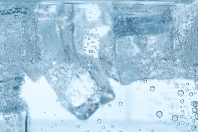Image of Refreshing soda water with ice cubes as background, closeup