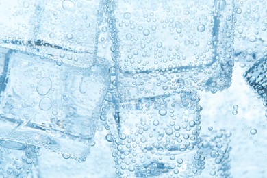 Image of Refreshing soda water with ice cubes as background, closeup