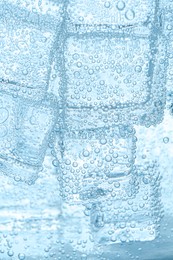 Image of Refreshing soda water with ice cubes as background, closeup