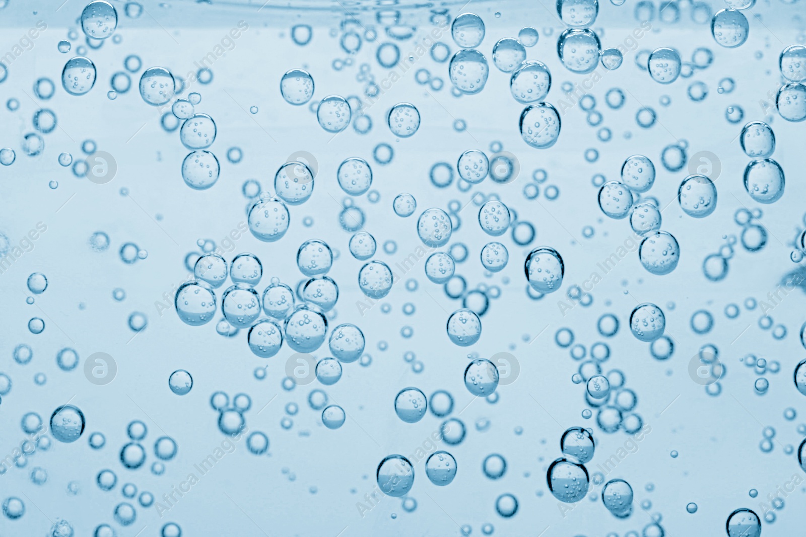 Soda water with bubbles as background, closeup Image of Soda water with bubbles as background, closeup