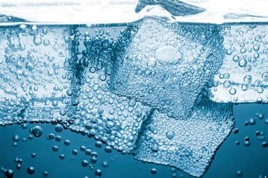 Image of Soda water with ice cubes as background, closeup