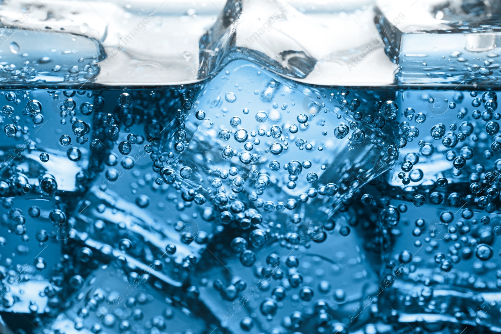 Soda water with ice cubes as background, closeup Image of Soda water with ice cubes as background, closeup