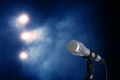 Image of Microphone on stage in smoke under spotlights. Singer's performance