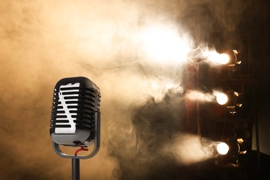 Image of Vintage microphone on stage in smoke under spotlights. Singer's performance