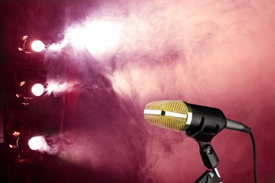 Image of Microphone on stage in smoke under spotlights. Singer's performance