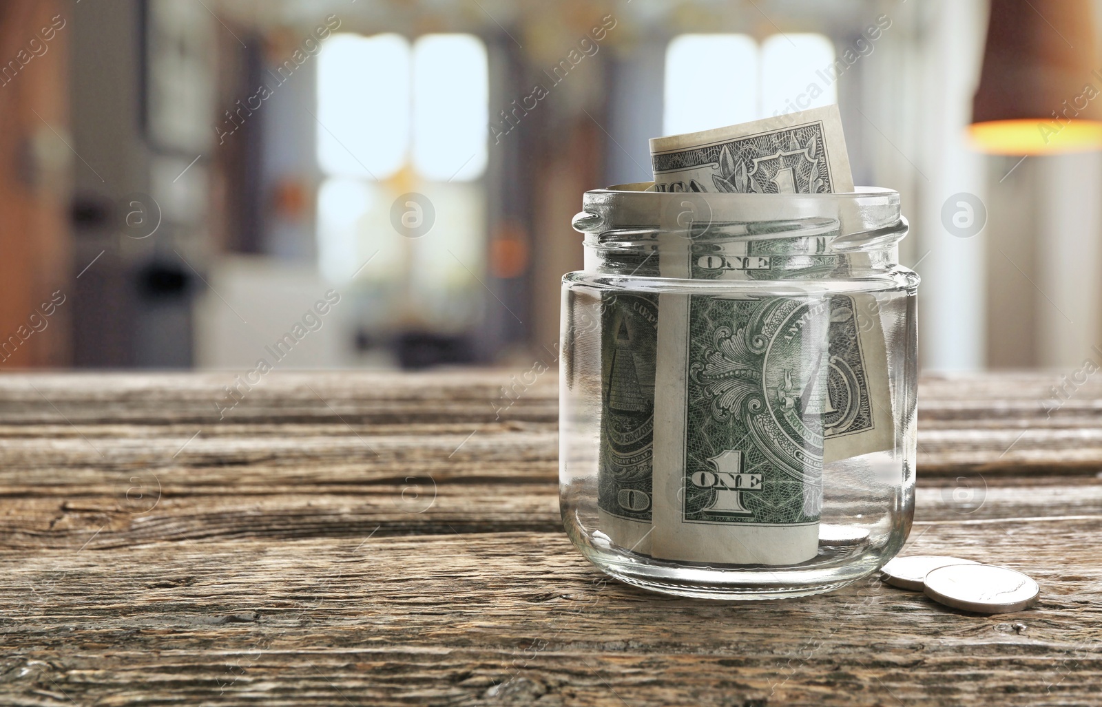 Tips jar with money on wooden table in cafe, space for text Image of Tips jar with money on wooden table in cafe, space for text