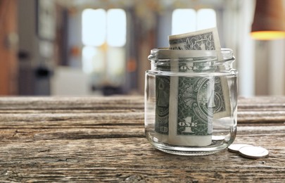 Image of Tips jar with money on wooden table in cafe, space for text