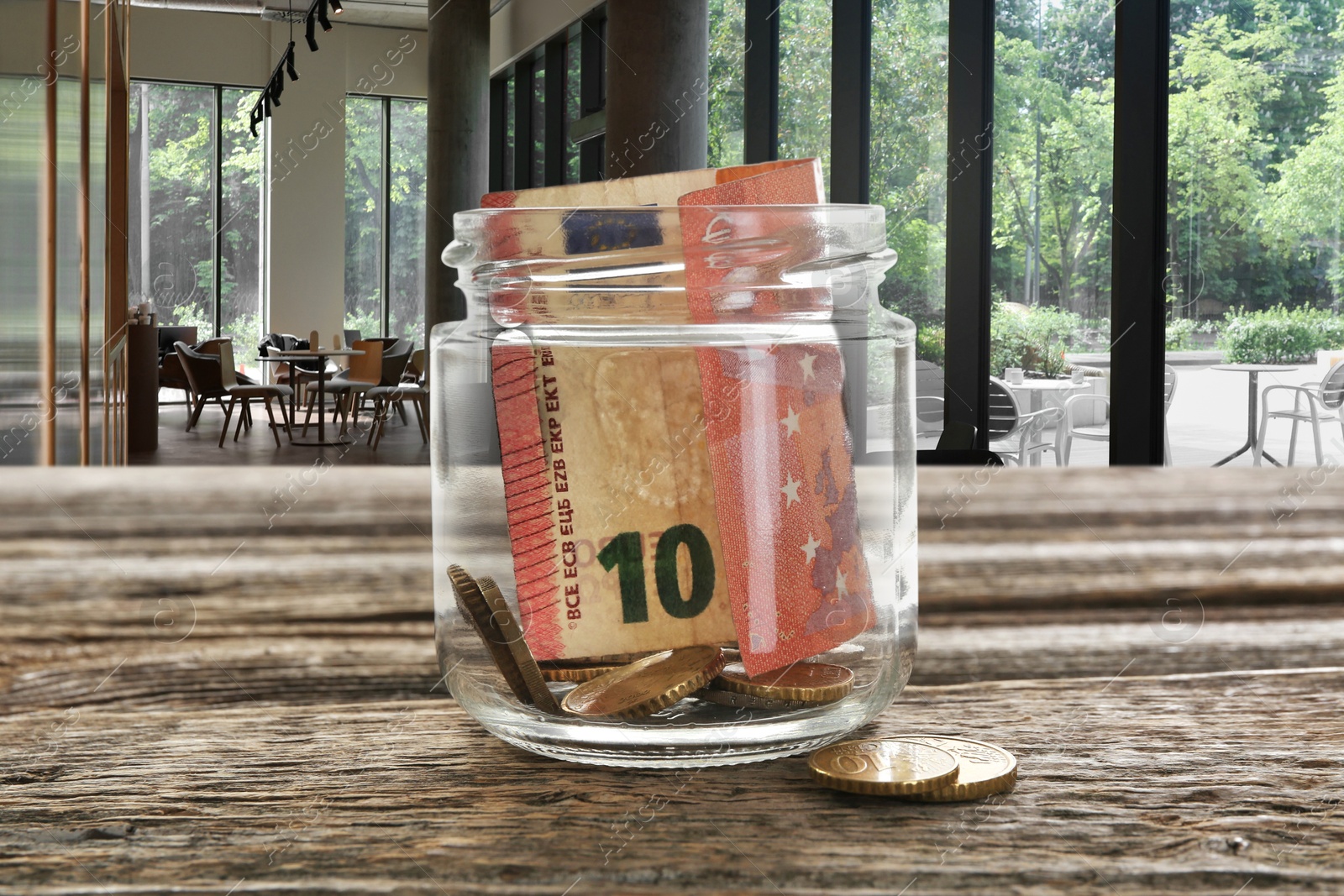 Tips jar with money on wooden table in cafe Image of Tips jar with money on wooden table in cafe