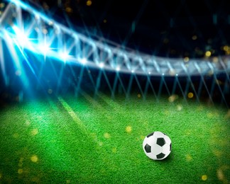 Image of Soccer ball on green grass at football stadium, space for text