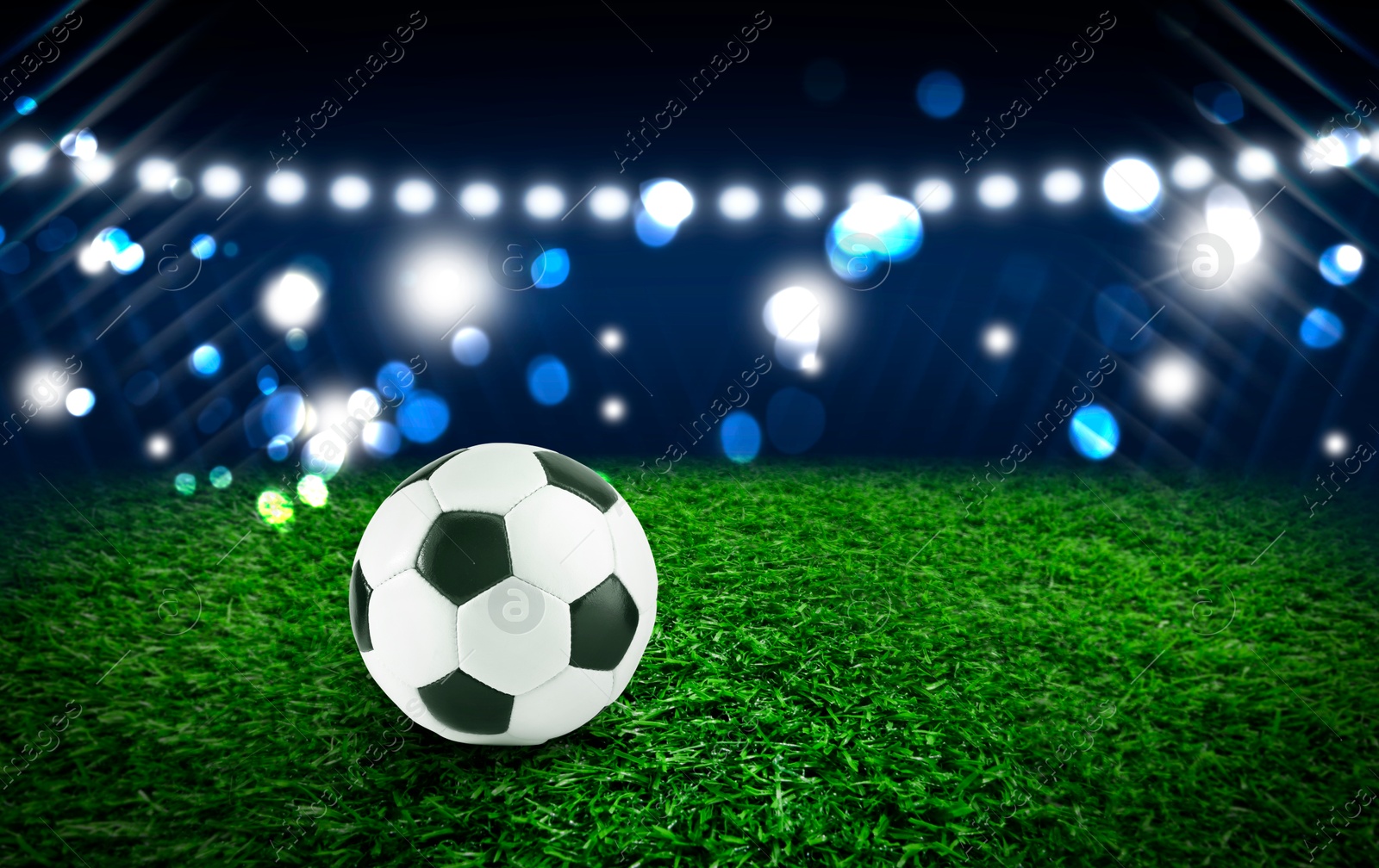 Soccer ball on green grass at football stadium, space for text Image of Soccer ball on green grass at football stadium, space for text