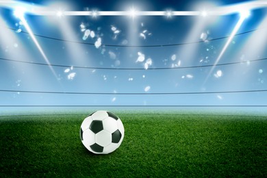 Image of Soccer ball on green grass at football stadium, space for text