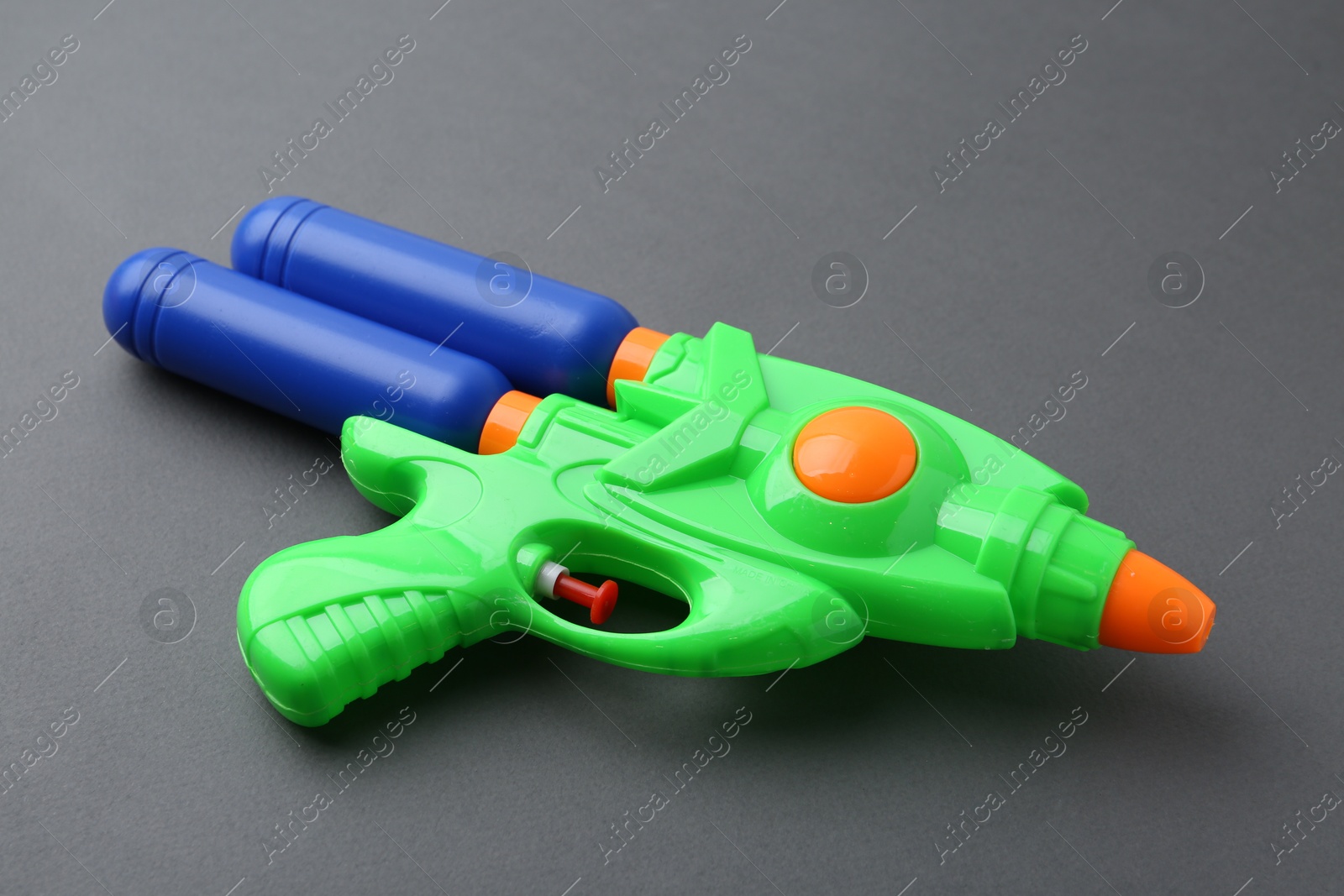 Bright plastic water gun on grey background, closeup Photo of Bright plastic water gun on grey background, closeup