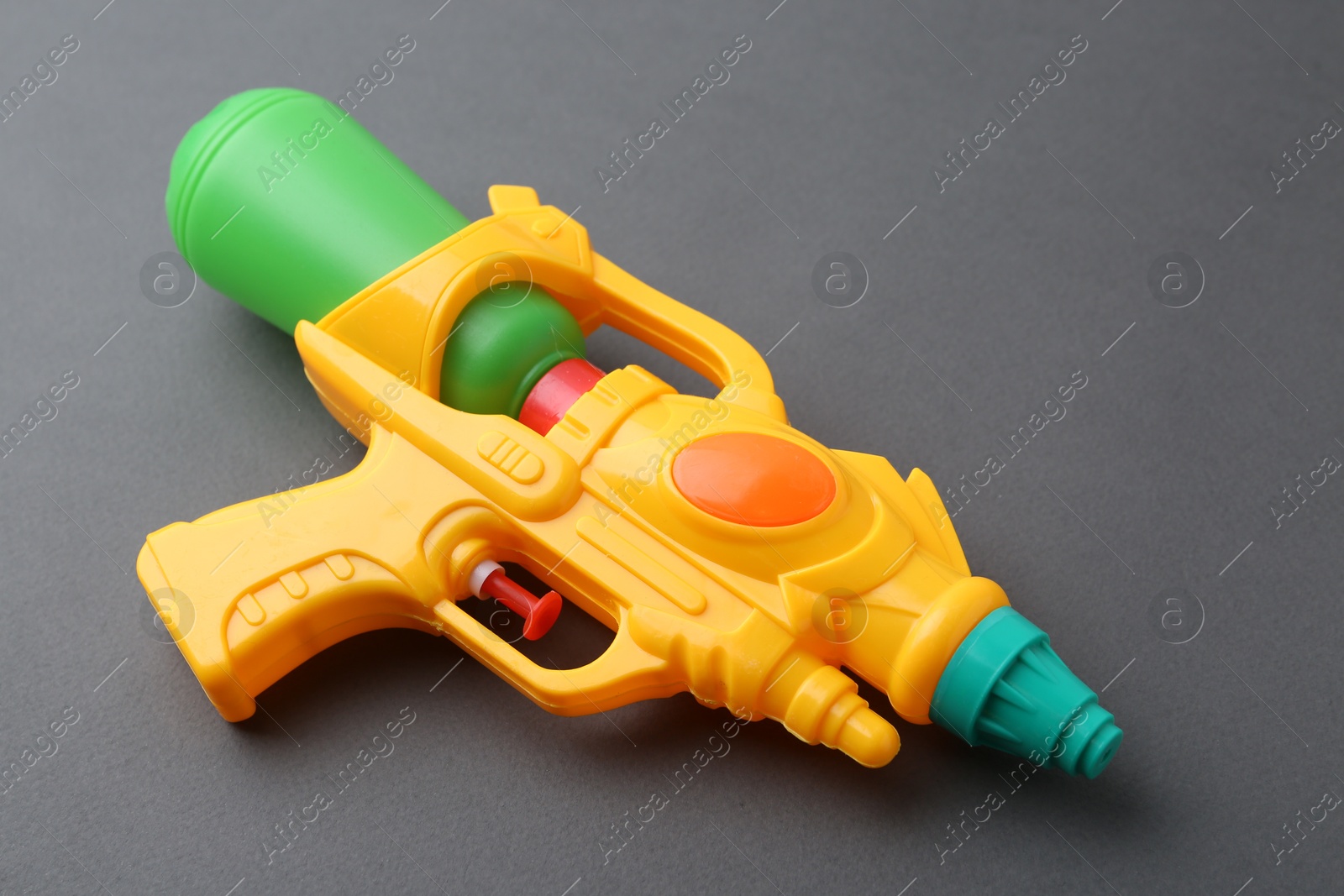 Bright plastic water gun on grey background, closeup Photo of Bright plastic water gun on grey background, closeup