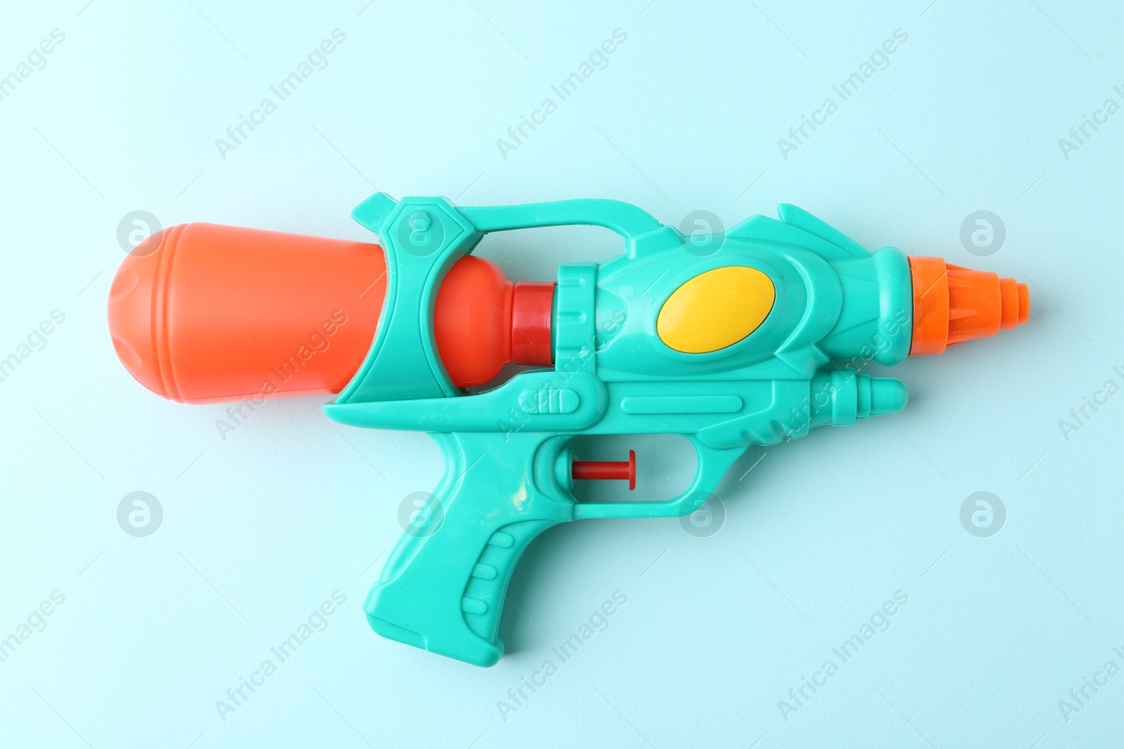 Bright plastic water gun on light blue background, top view Photo of Bright plastic water gun on light blue background, top view