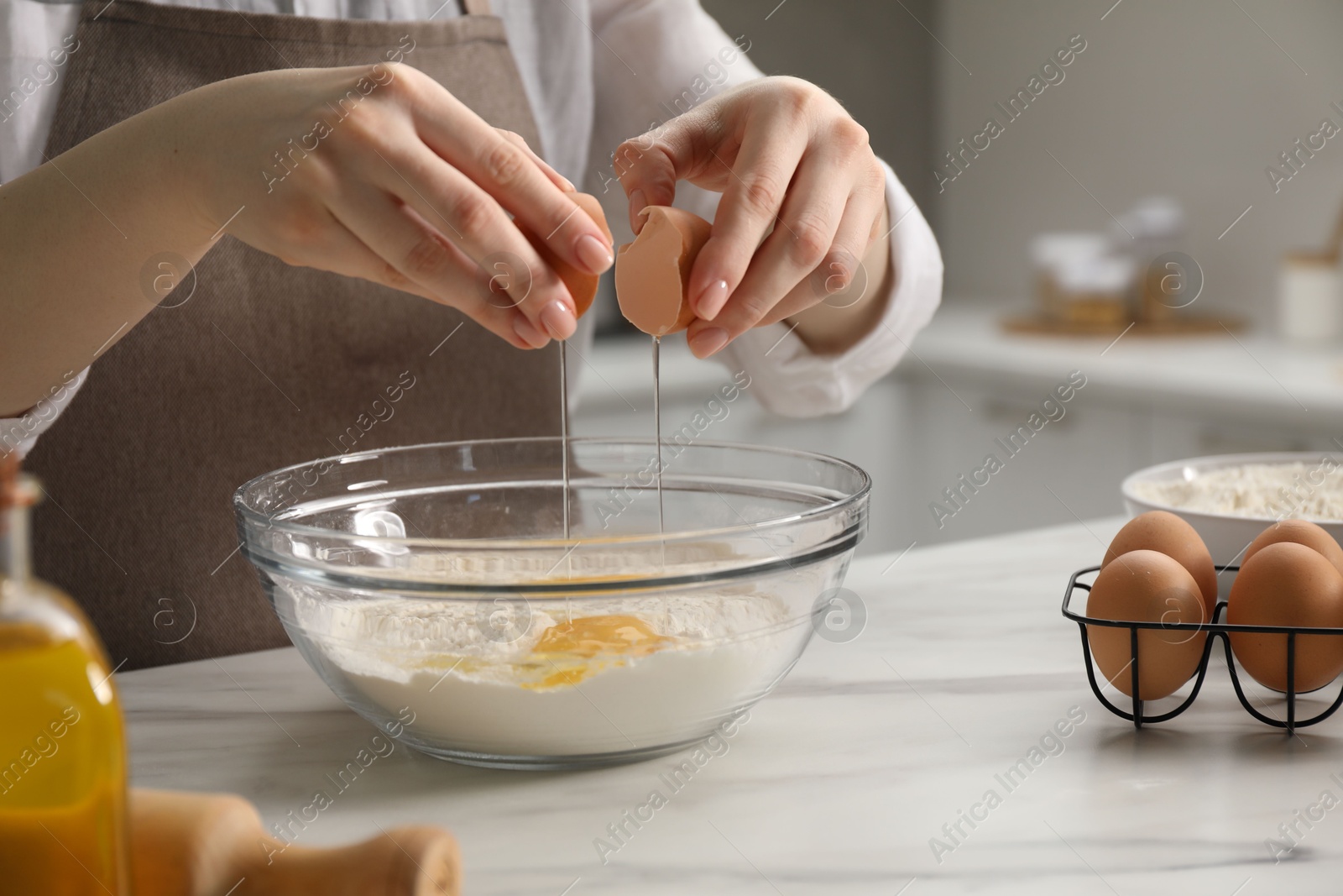 Making khinkali. Woman adding egg into bowl at table in kitchen, closeup Photo of Making khinkali. Woman adding egg into bowl at table in kitchen, closeup