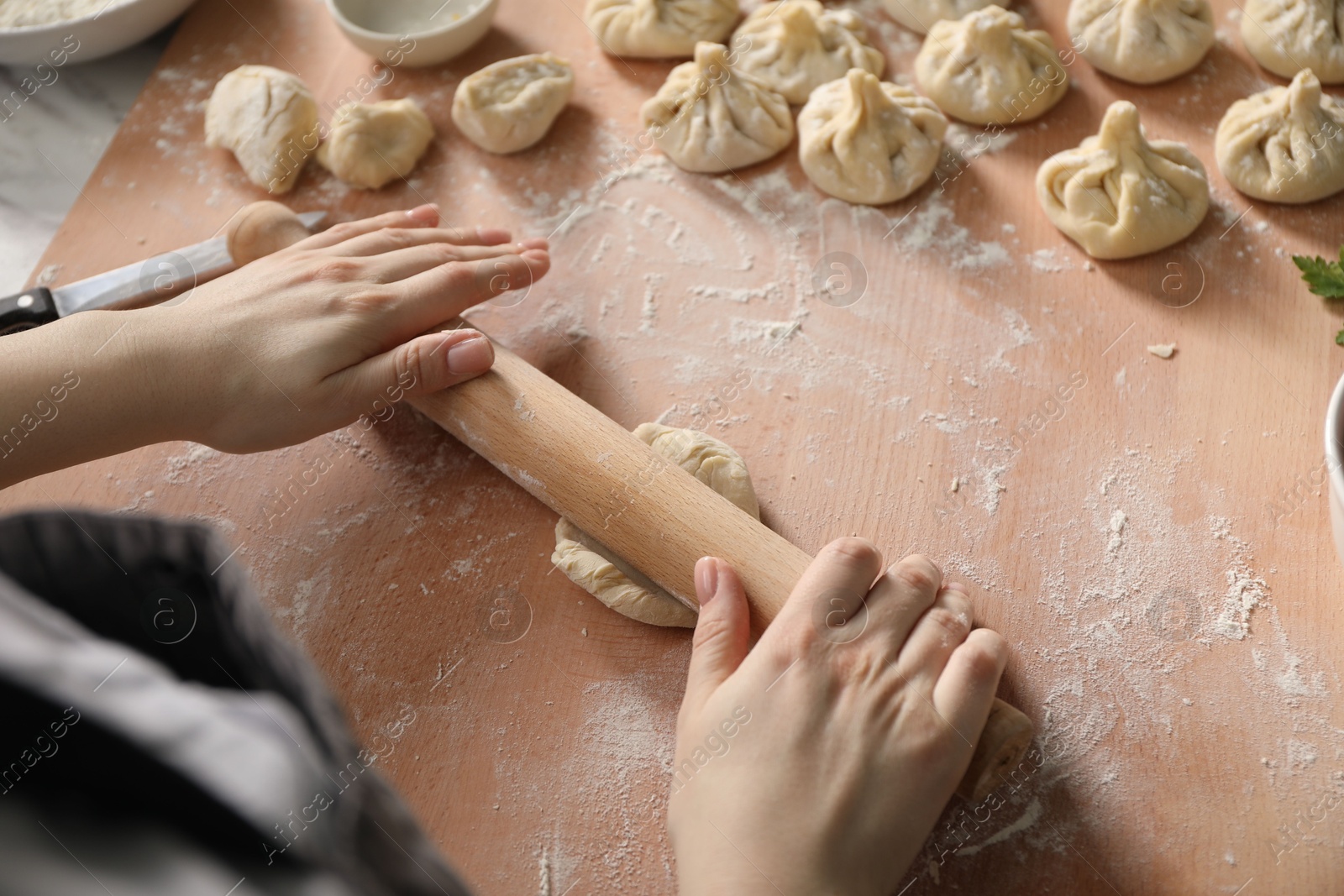Woman making khinkali at table in kitchen, above view Photo of Woman making khinkali at table in kitchen, above view