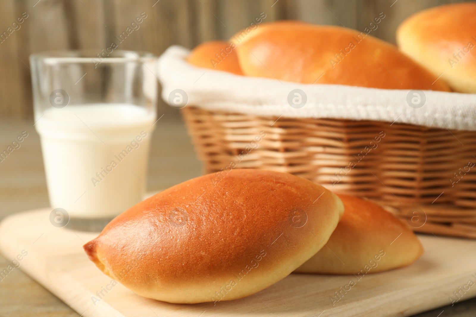 Tasty baked patties and milk on wooden table, closeup Photo of Tasty baked patties and milk on wooden table, closeup