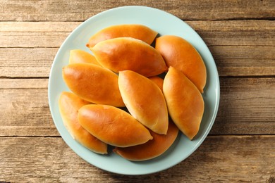 Photo of Tasty baked patties on wooden table, top view