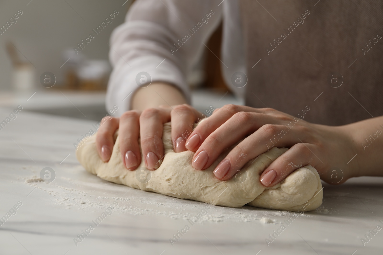Making pretzels. Woman kneading dough at table in kitchen, closeup Photo of Making pretzels. Woman kneading dough at table in kitchen, closeup