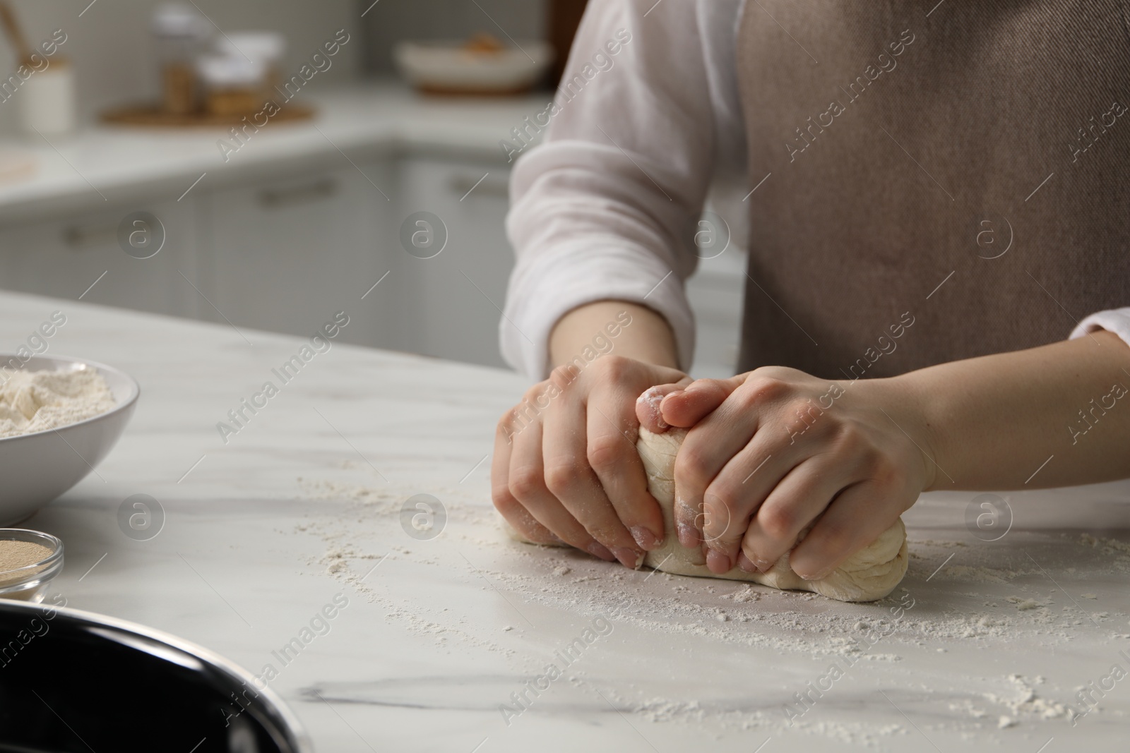 Making pretzels. Woman kneading dough at table in kitchen, closeup Photo of Making pretzels. Woman kneading dough at table in kitchen, closeup