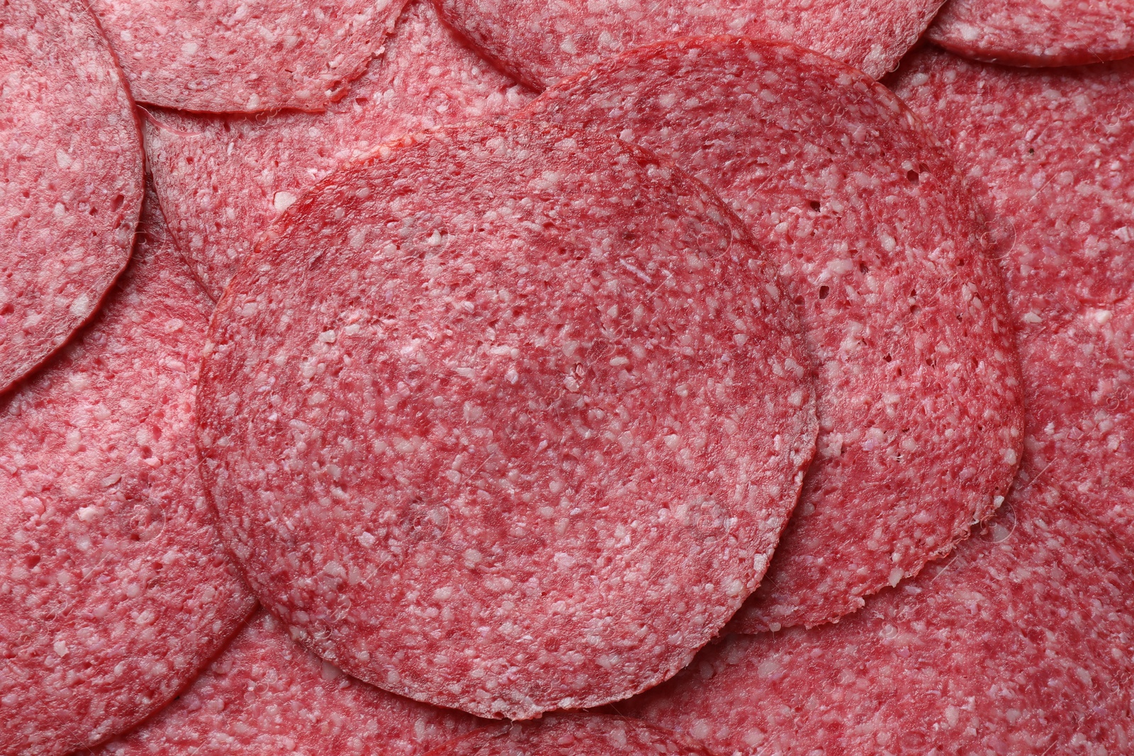 Photo of Slices of tasty smoked sausage as background, top view