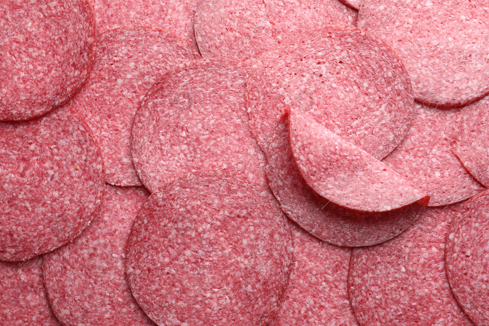 Slices of tasty smoked sausage as background, top view Photo of Slices of tasty smoked sausage as background, top view