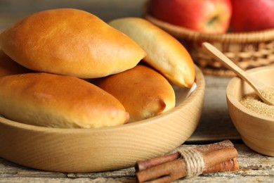 Photo of Tasty baked patties and ingredients on wooden table, closeup
