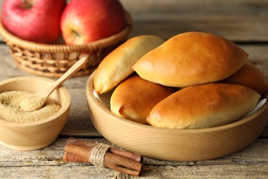 Photo of Tasty baked patties and ingredients on wooden table, closeup