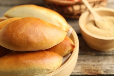 Photo of Tasty baked patties on wooden table, closeup