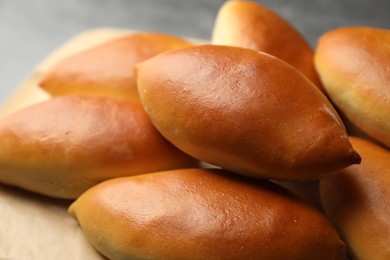 Photo of Tasty baked patties on light grey table, closeup