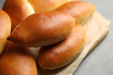 Photo of Tasty baked patties on light grey table, closeup
