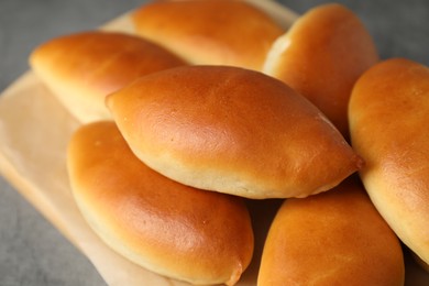 Photo of Tasty baked patties on light grey table, closeup
