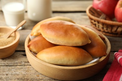 Photo of Tasty baked patties and ingredients on wooden table, closeup