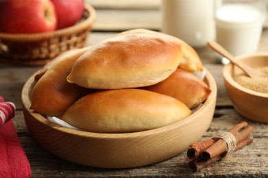 Photo of Tasty baked patties and ingredients on wooden table, closeup