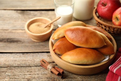 Photo of Tasty baked patties and ingredients on wooden table, closeup