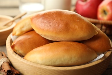 Photo of Tasty baked patties and ingredients on wooden table, closeup
