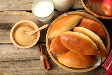 Photo of Tasty baked patties and ingredients on wooden table, flat lay