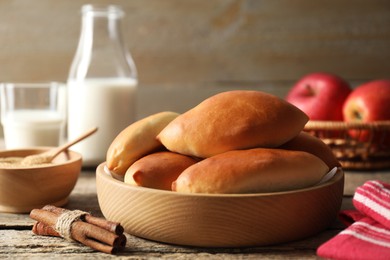Photo of Tasty baked patties and ingredients on wooden table, closeup
