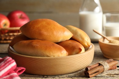 Photo of Tasty baked patties and ingredients on wooden table, closeup