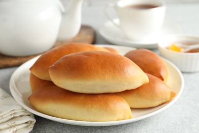 Photo of Tasty baked patties on light grey table, closeup