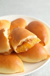 Photo of Tasty baked patties with orange jam on light grey table, closeup
